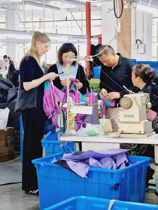 Mylene and Stella on the left, discussing stichings with a line manager and seamstress.