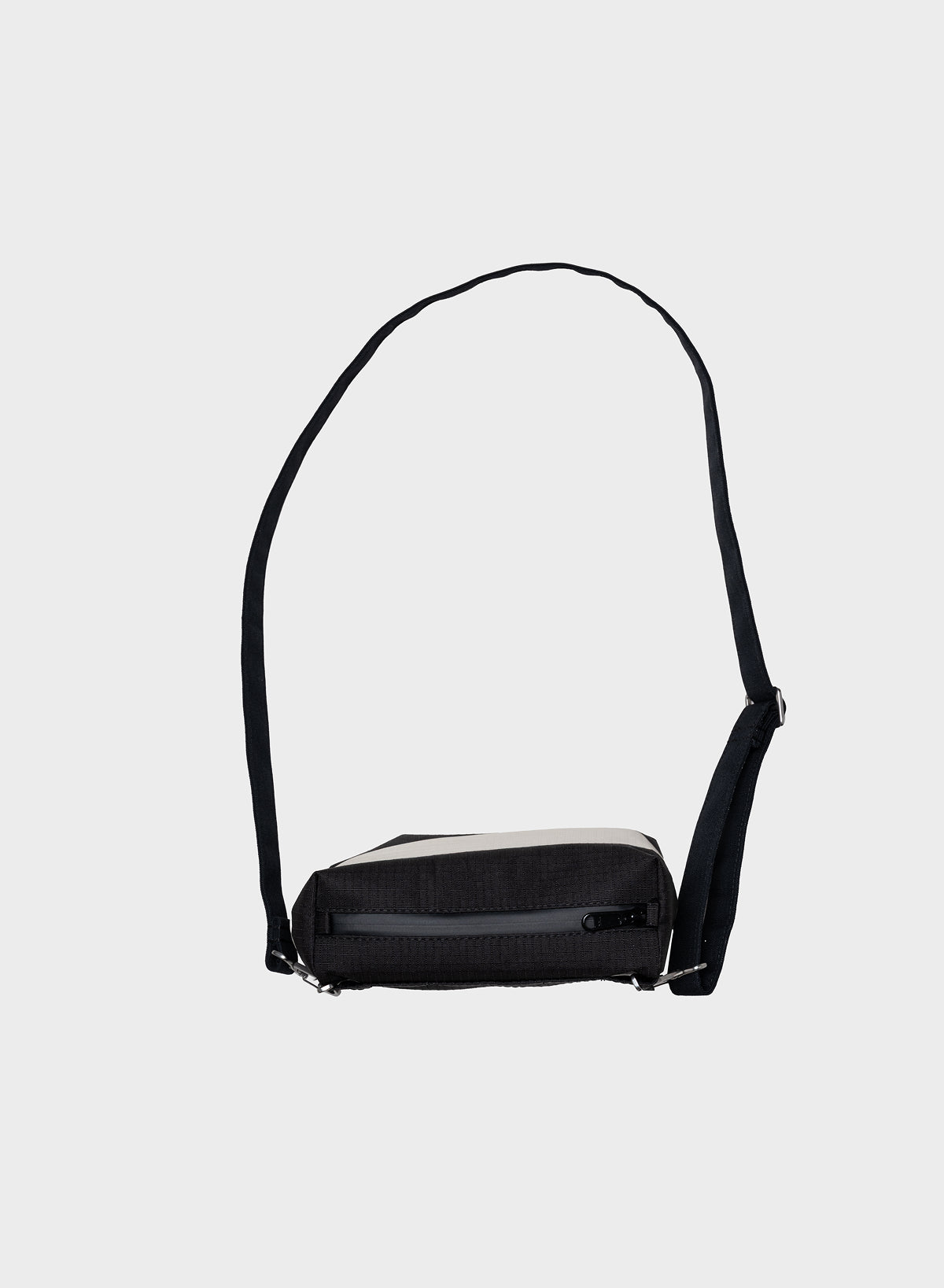 A black crossbody bag with a wide, adjustable black strap and a contrasting light gray horizontal stripe across the front, shown against a plain light gray background.