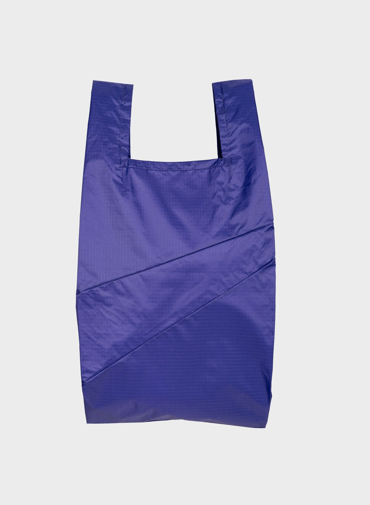A reusable plastic shopping bag in a vibrant periwinkle blue color, laid flat against a light gray background.